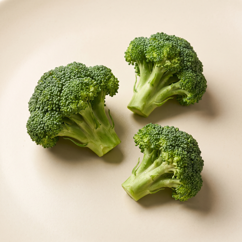 three fresh broccoli florets with detailed tiny green buds